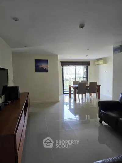 Spacious living room with modern furniture and natural light, perfect for relaxation and entertainment.