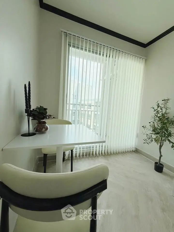 Bright study room with modern decor and large window with vertical blinds.