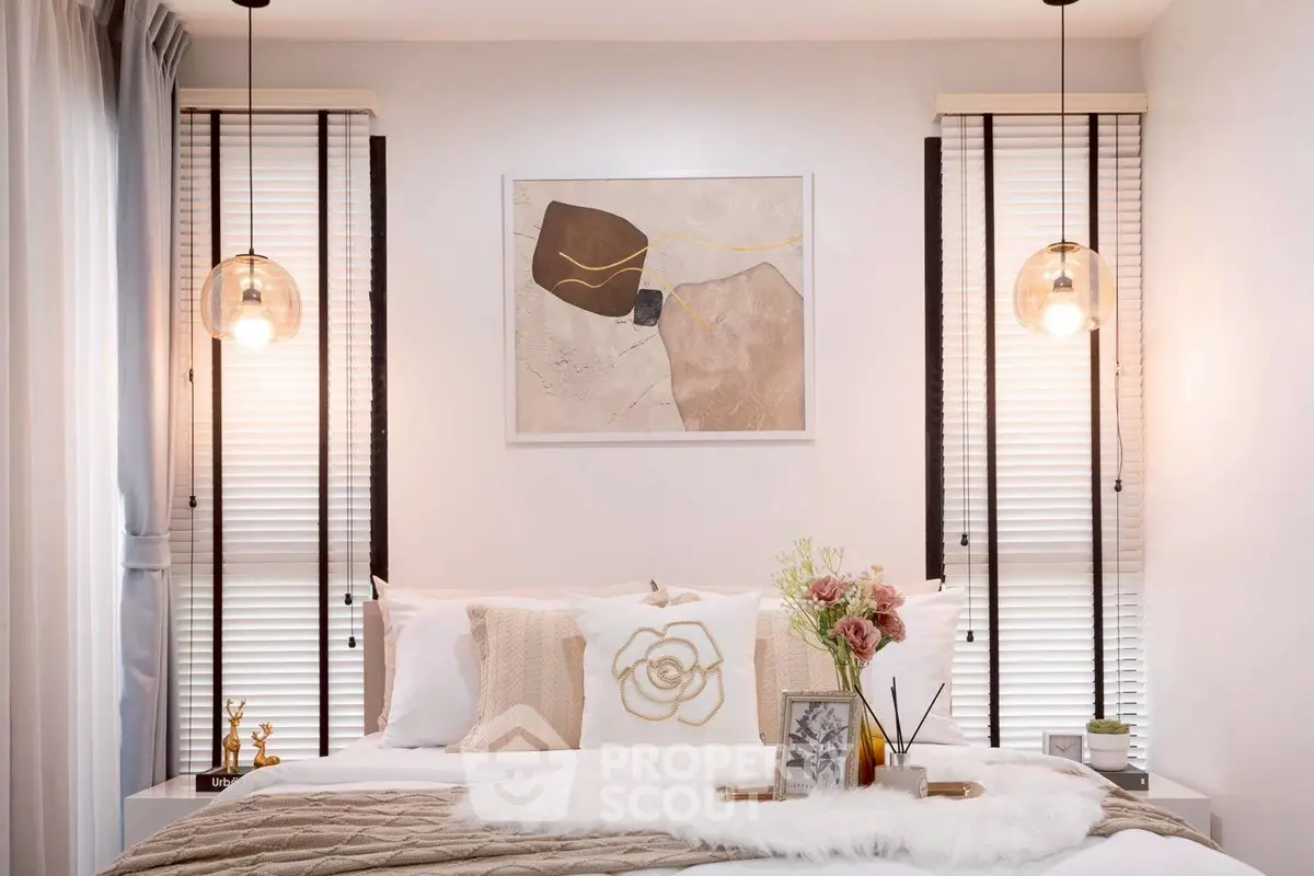 Elegant bedroom with modern decor, pendant lights, and abstract art, creating a cozy and stylish ambiance.