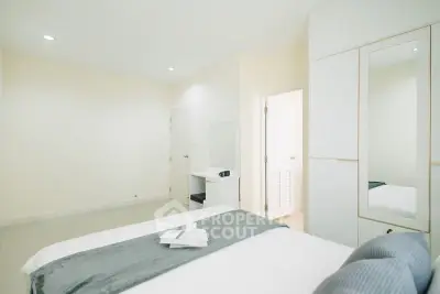 Bright and modern bedroom with sleek design and ample storage space.