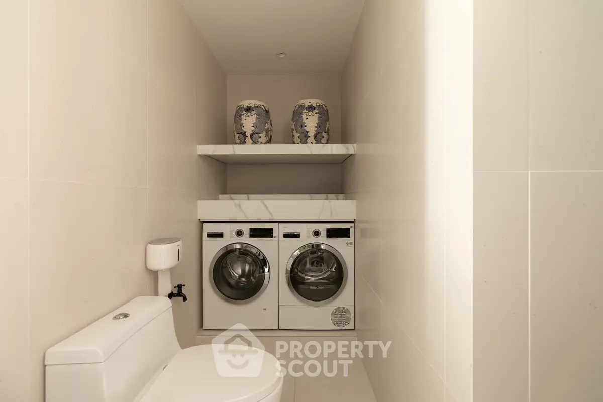 Modern bathroom with integrated laundry appliances and elegant decor