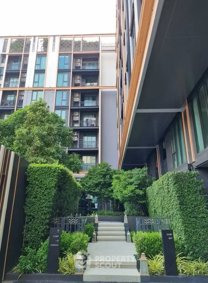 Modern apartment building with lush greenery and elegant entrance