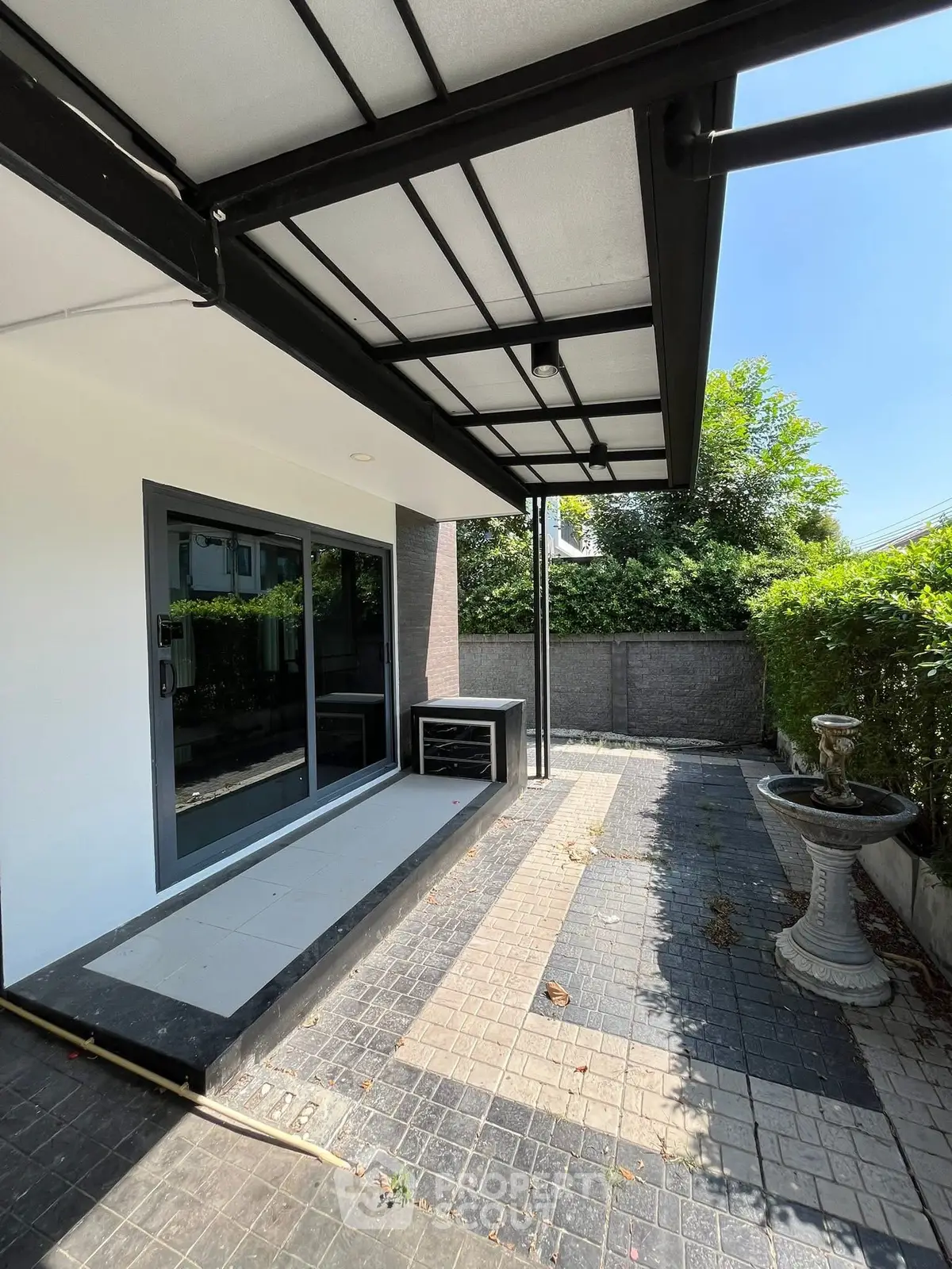 Modern patio with sleek awning and garden view, perfect for outdoor relaxation.