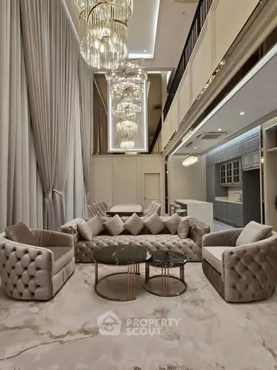 Luxurious living room with high ceilings, elegant chandeliers, and plush seating in a modern open layout.