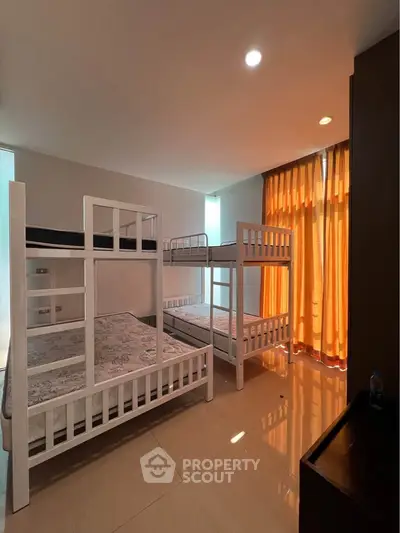 Spacious bedroom with bunk beds and large window for natural light