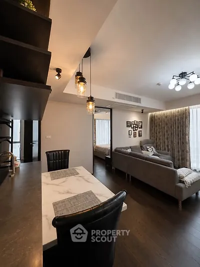 Modern living room with stylish decor and open layout, featuring elegant lighting and cozy seating area.