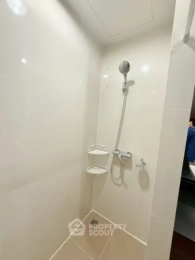 Modern minimalist shower area with sleek fixtures and neutral tiles.