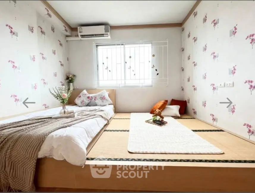 Charming bedroom with tatami flooring and floral wallpaper, perfect for a cozy retreat.