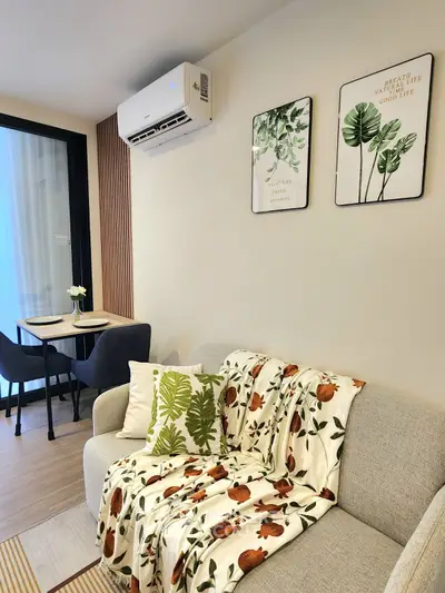 Charming living room with cozy sofa, stylish decor, and dining area, perfect for modern living.