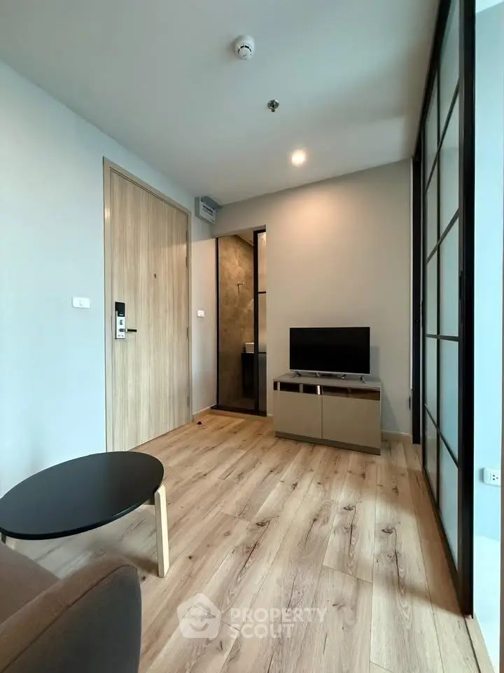 Modern living room with wooden flooring and sleek furniture in a stylish apartment.