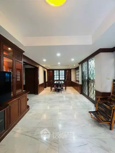 Spacious living room with elegant wooden decor and marble flooring