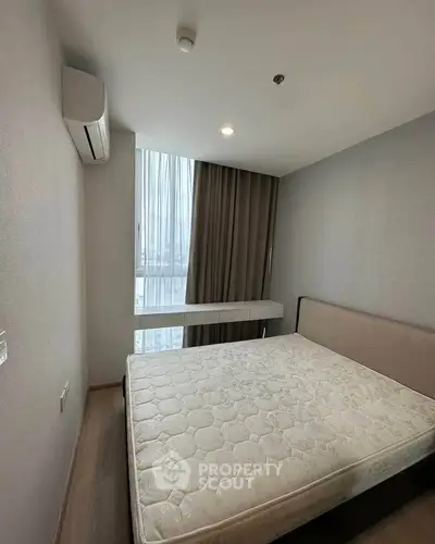 Modern bedroom with large window and minimalist design in a high-rise apartment.