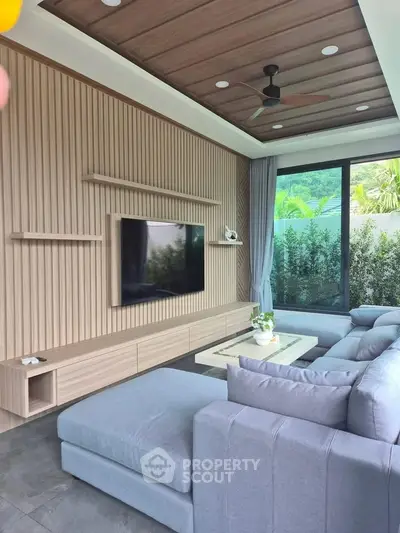 Modern living room with stylish wood paneling, large sectional sofa, and floor-to-ceiling windows with garden view.
