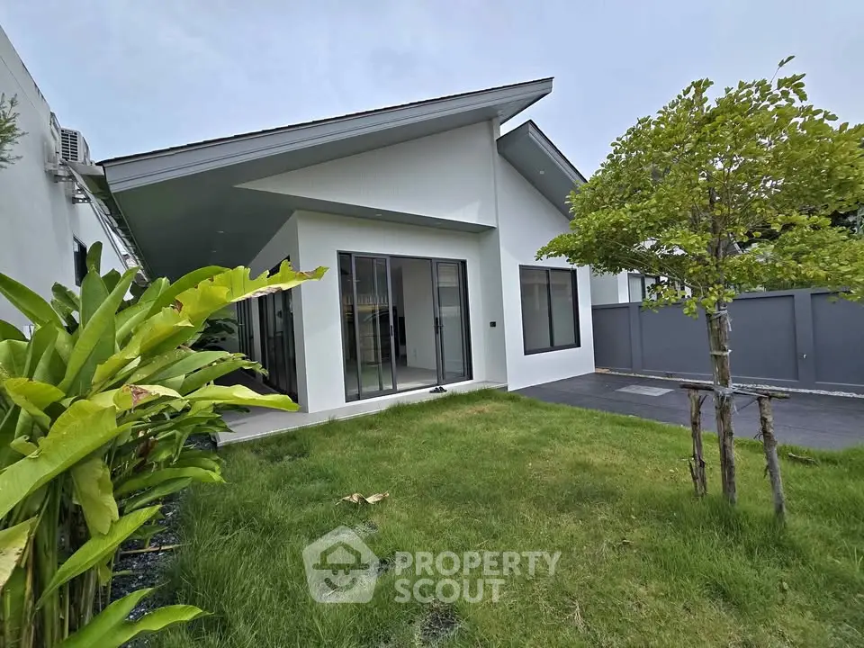 Modern single-story house with sleek design and lush green lawn, perfect for contemporary living.