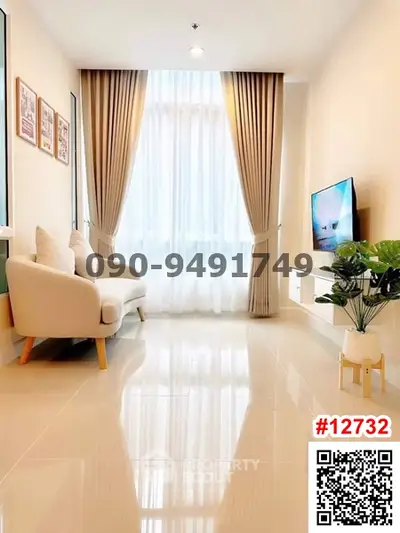 Modern living room with elegant decor and large window, featuring a cozy sofa and wall-mounted TV.