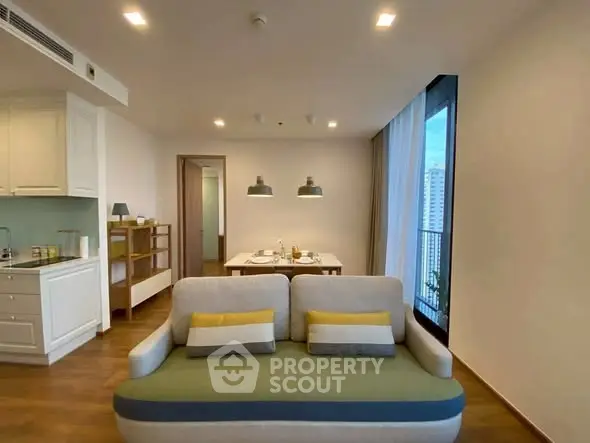 Modern living room with cozy sofa and dining area in open layout apartment.
