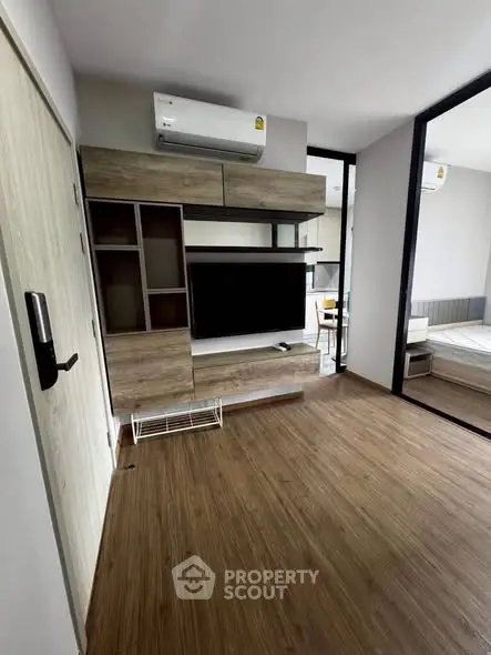 Modern living room with wooden flooring and sleek TV unit