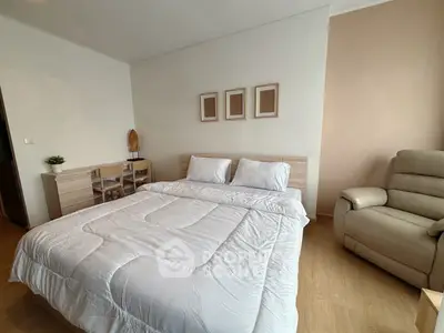Cozy bedroom with modern decor and comfortable seating in a stylish apartment.