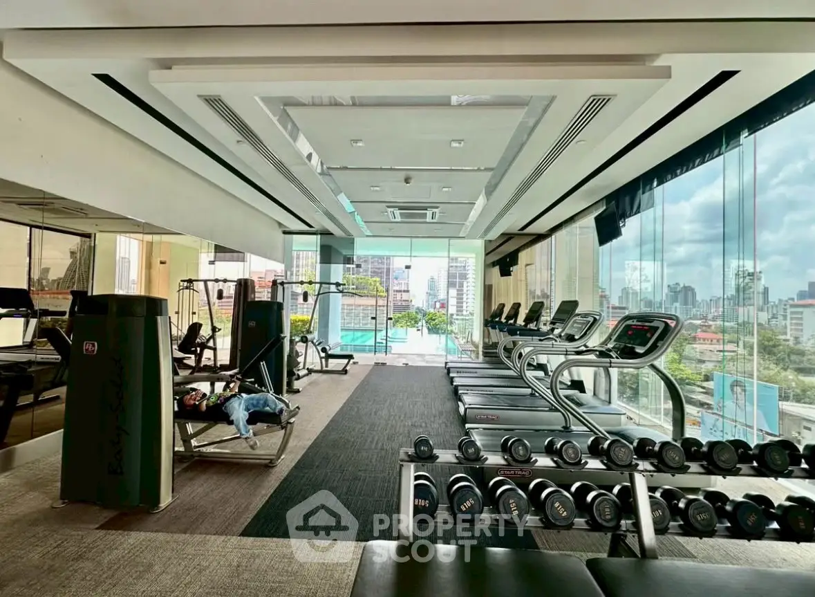 Luxurious high-rise gym with panoramic city views and modern fitness equipment.