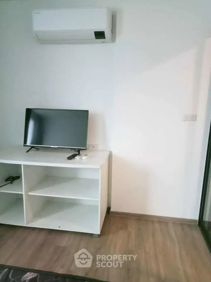 Modern living room with sleek TV setup and air conditioning unit