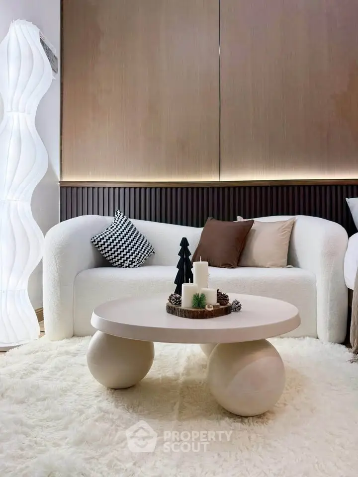 Stylish modern living room with cozy white sofa and unique round coffee table.