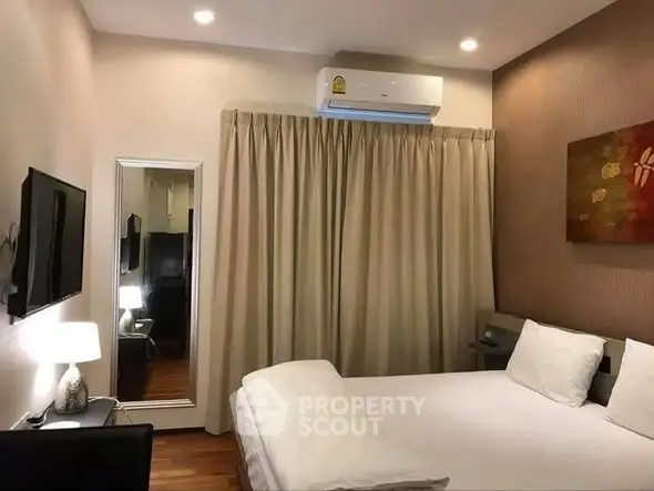 Cozy bedroom with modern decor and air conditioning, perfect for relaxation.