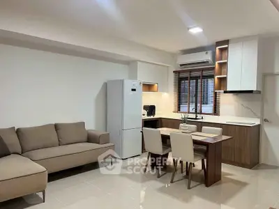 Modern open-plan kitchen and living room with sleek furniture and appliances.