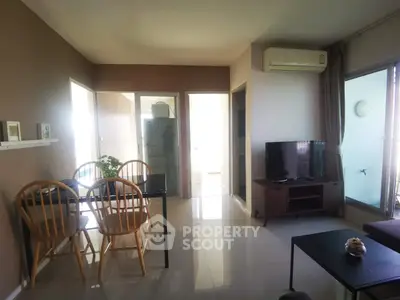 Modern living room with dining area and natural light, featuring sleek furniture and air conditioning.