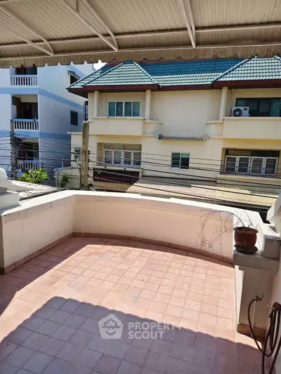 Charming balcony with tiled flooring and street view in a residential neighborhood.