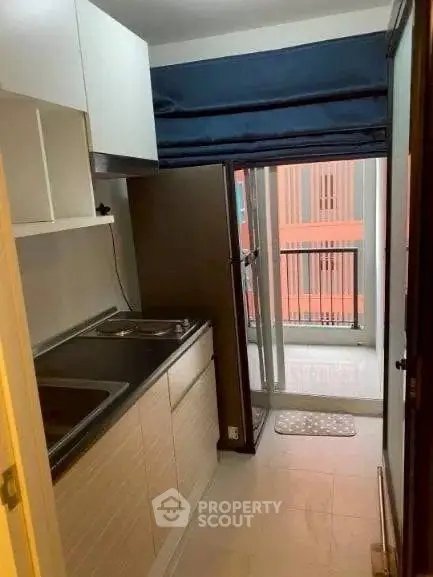 Compact kitchen with balcony access in modern apartment