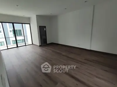 Spacious modern living room with large windows and wooden flooring
