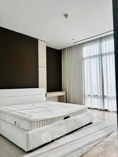 Luxurious bedroom with elegant decor and large windows offering natural light