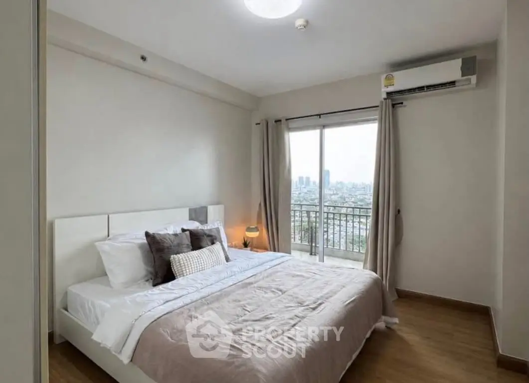 Spacious bedroom with city view and balcony access in modern apartment