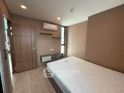 Modern bedroom with minimalist design, featuring a large bed and built-in air conditioning.