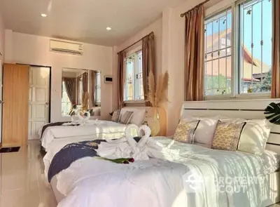 Spacious bedroom with twin beds and elegant decor in sunlit room