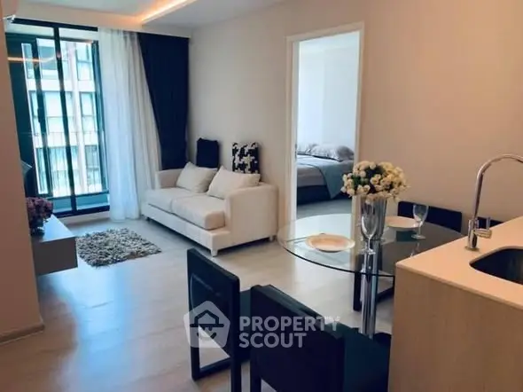 Modern open-plan living room with cozy seating and dining area, featuring elegant decor and natural light.