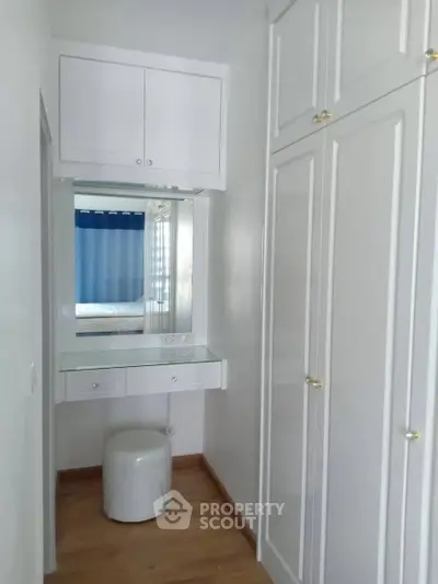 Chic bedroom corner with built-in wardrobe and vanity mirror, perfect for stylish storage solutions.