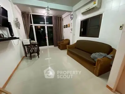 Spacious living room with modern decor and large window for natural light.