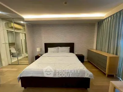 Spacious bedroom with modern decor and ensuite bathroom in luxury apartment.