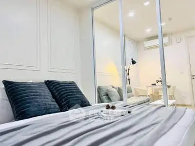 Modern bedroom with stylish decor and cozy ambiance, featuring elegant bedding and a mirrored wall.