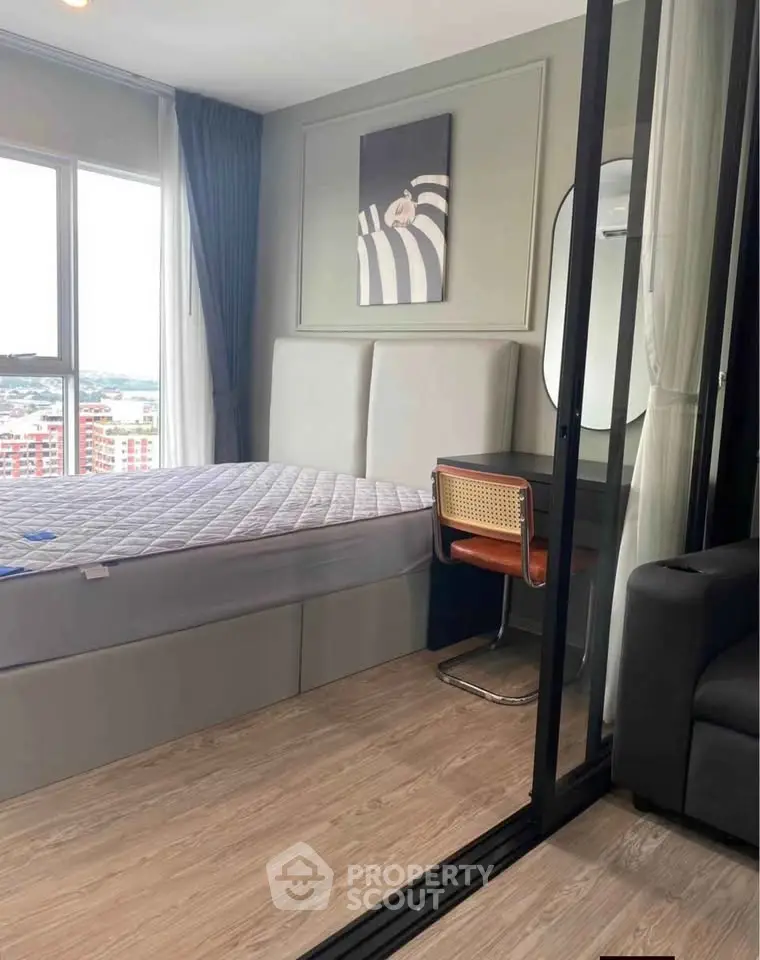 Modern bedroom with stylish decor and large window offering city views.