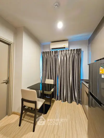 Modern kitchen with sleek design, featuring a dining area and stainless steel appliances.