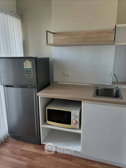 Modern kitchen with sleek fridge and microwave in compact layout