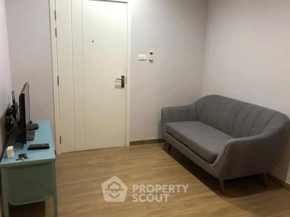 Cozy living room with modern sofa and TV setup, perfect for relaxation.