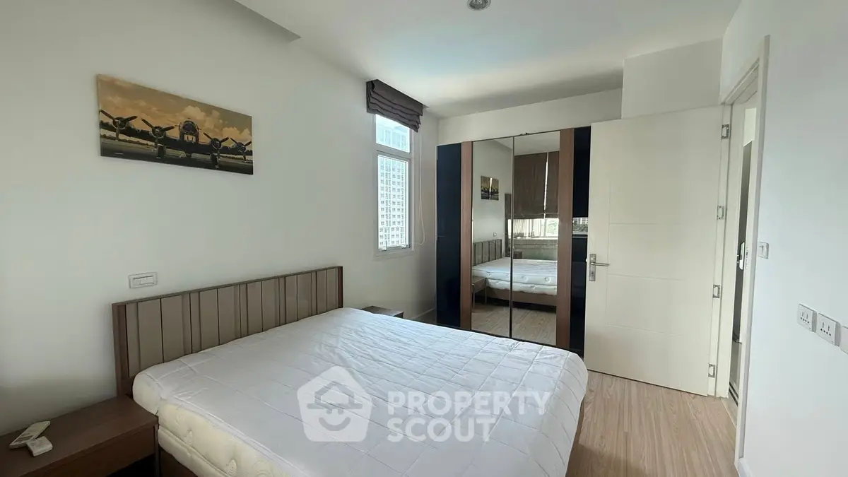 Modern bedroom with large mirror wardrobe and city view window