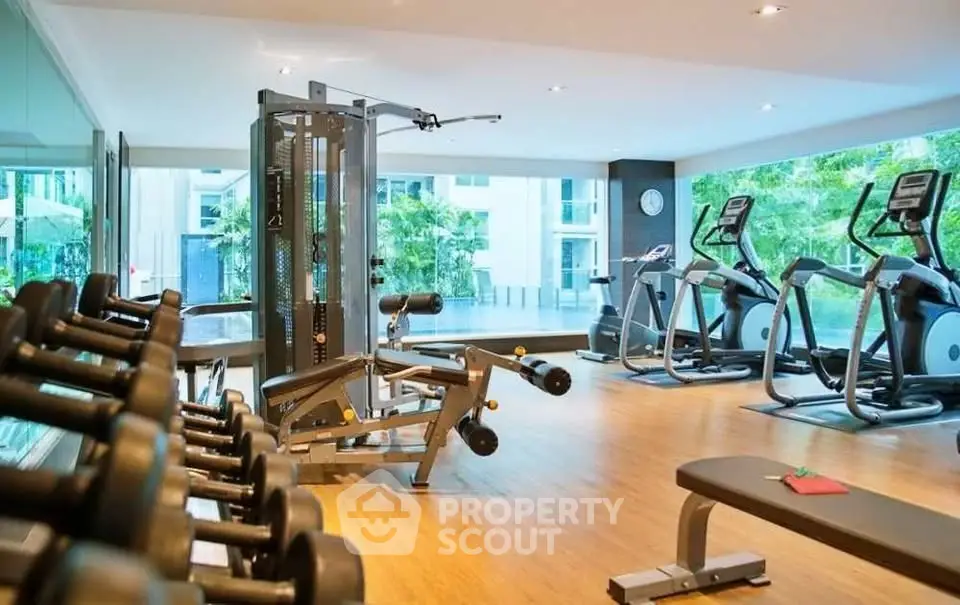 Modern gym with state-of-the-art equipment and large windows offering a refreshing view.