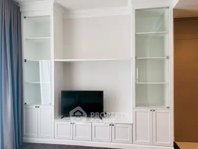 Elegant living room with built-in white cabinetry and modern TV setup
