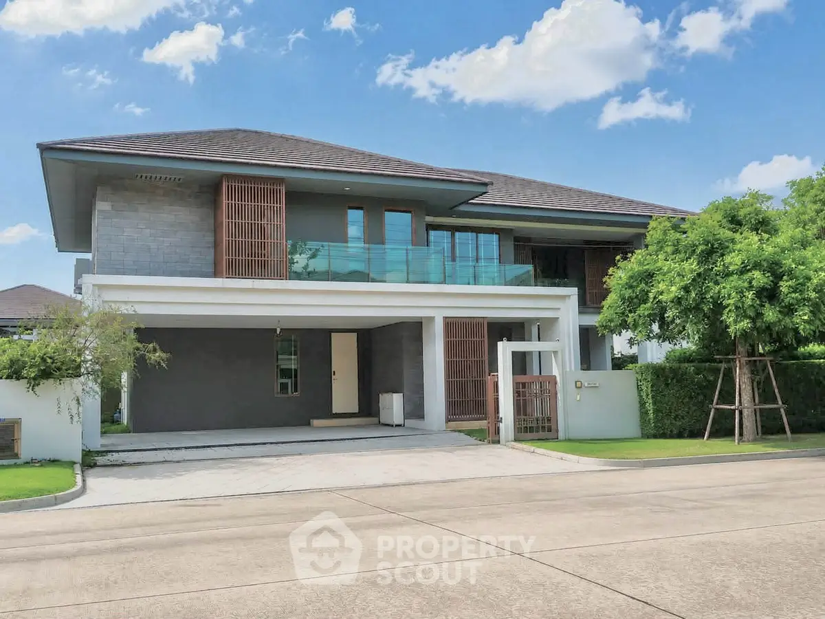 Modern two-story house with spacious driveway and lush greenery, perfect for family living.