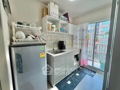 Compact kitchen with balcony access and modern appliances in urban apartment