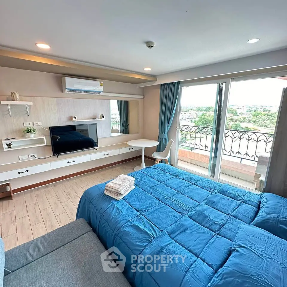 Spacious bedroom with modern decor and large windows offering a stunning view, perfect for relaxation.